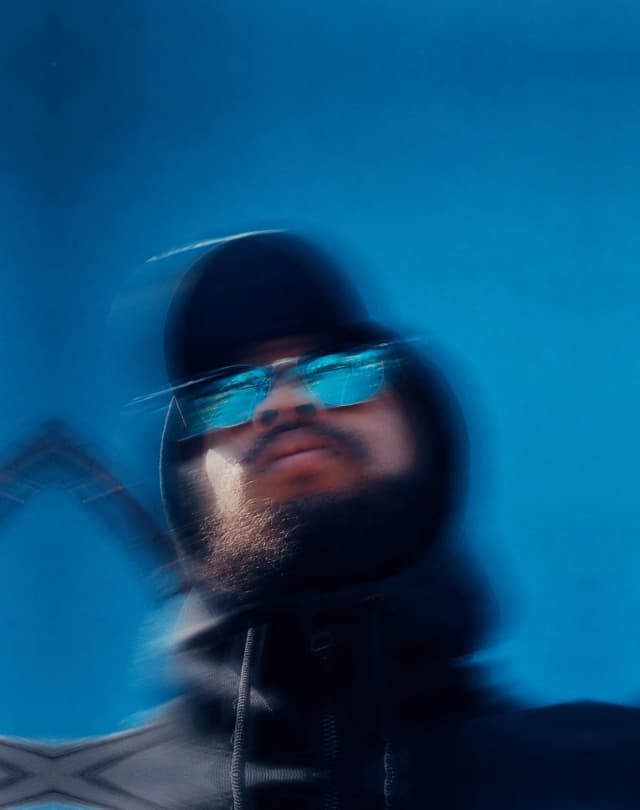 Creative portrait of Jared Gibbs in a hood and sunglasses